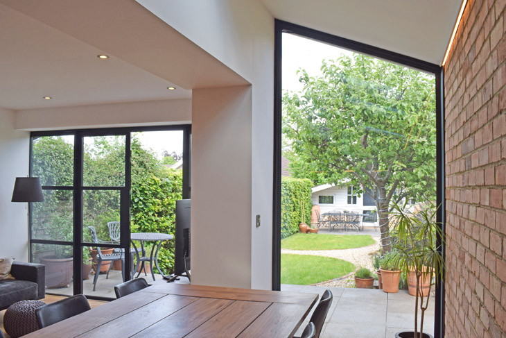 French doors connect the outdoors to the indoors and a picture window frames the garden view.