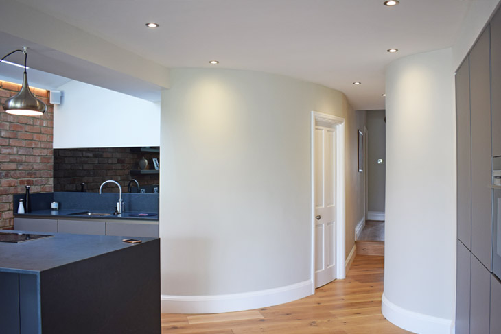 The use of curved walls to connect spaces and keep the living flow.