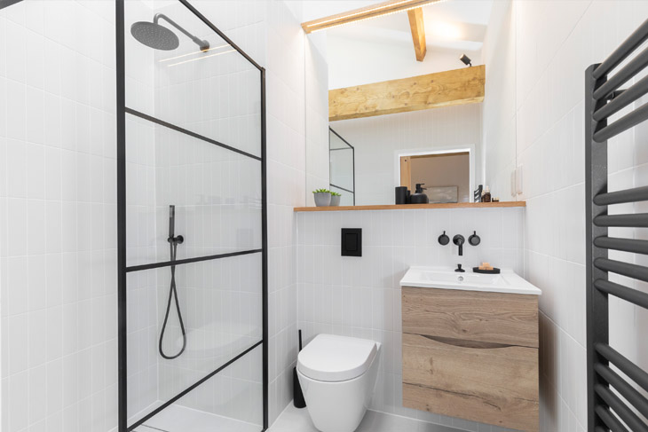 Ensuite bathroom with oak beams and crittell style shower screen in newly refurbished victorian terrace house in Cheltenham, Gloucestershire.