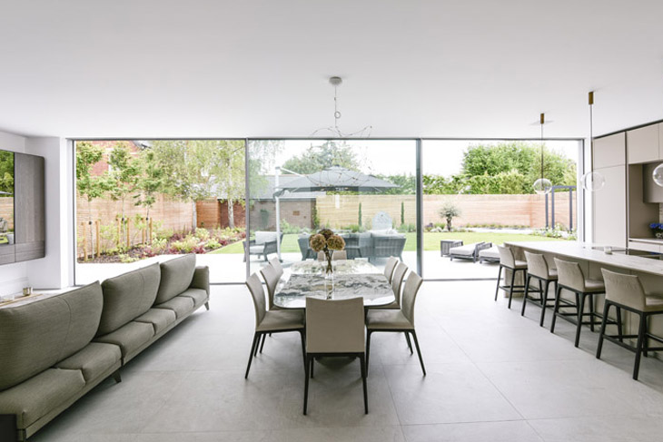 Interior of architect designed contemporary extension with large, glazed sliding doors to rear landscaped garden.