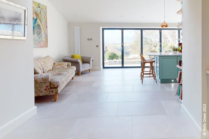 A bright, airy kitchen with expansive bifold doors and tiled floor.